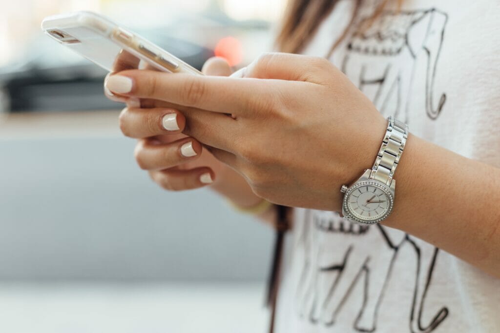 woman's hands using smartphone